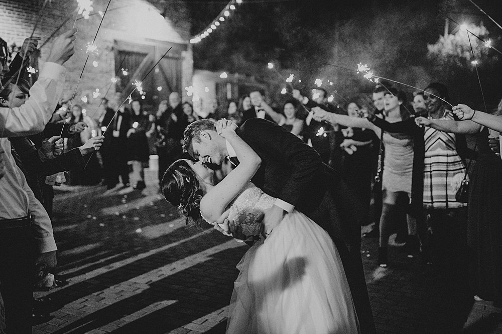 couple shares a kiss during their sparkler send off