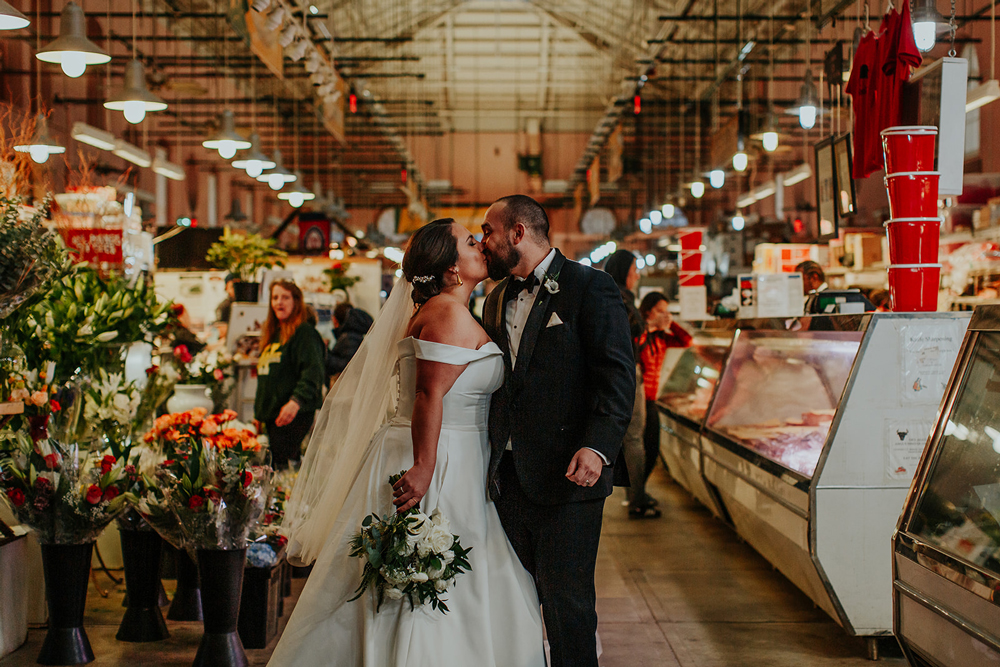 Couple shares a kiss before wedding reception at Eastern Market