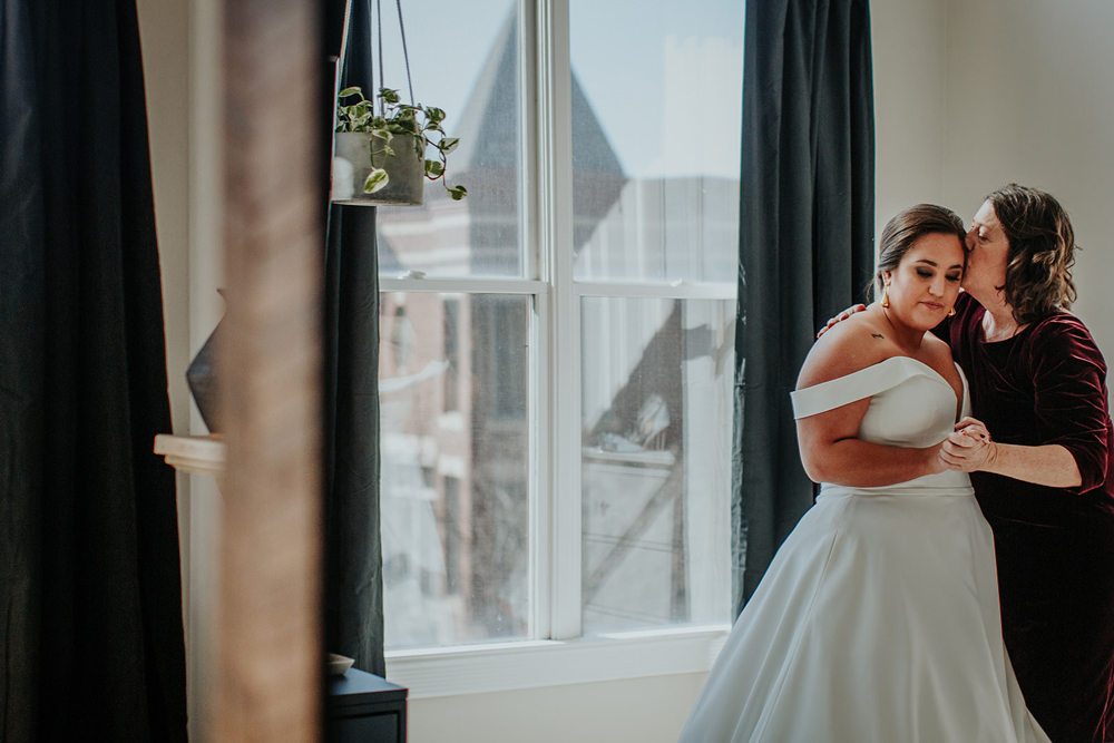 a bride and her mother sharing a special moment while getting ready