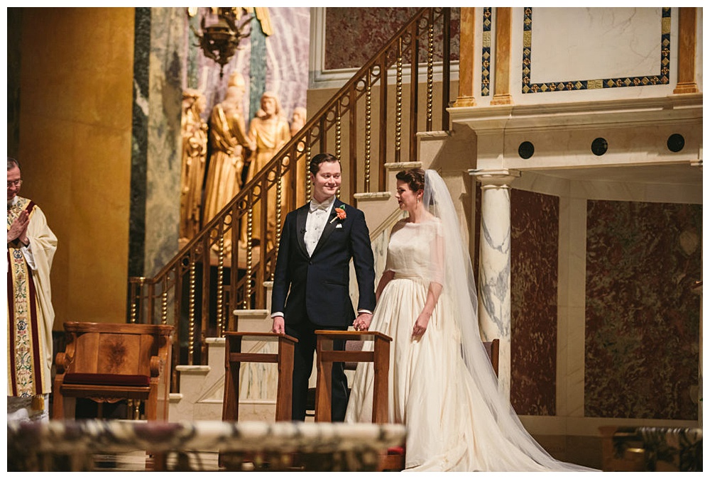 couple enjoying a moment during the wedding ceremony at St Matthew's Cathedral, DC