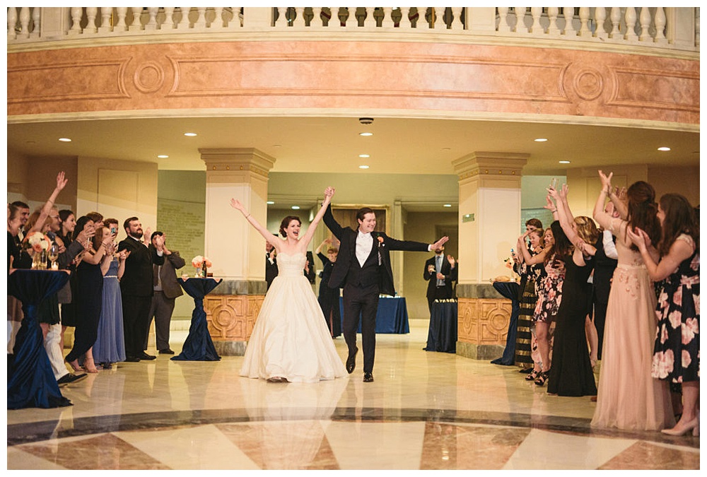 Couple's grand entrance as their guests celebrate and welcome them, at National Museum of Women in the Arts.