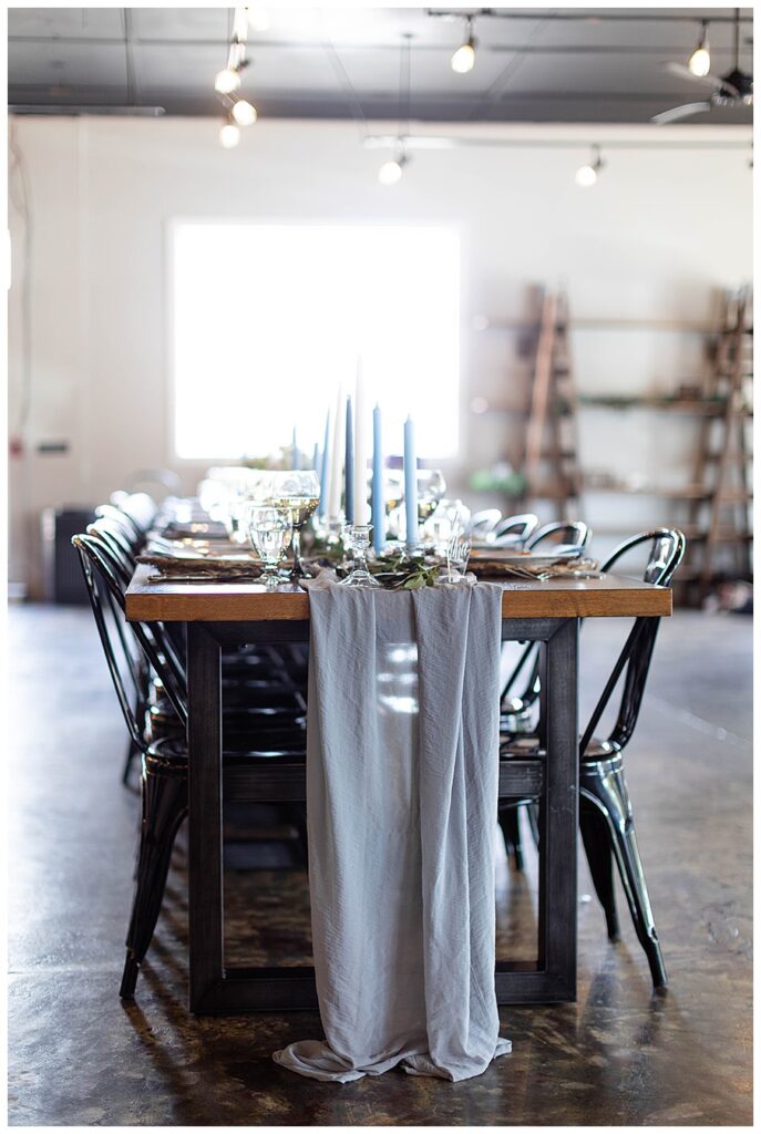 tablescape with taper candles and grey runner in industrial wedding venue