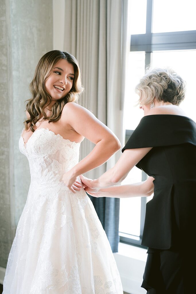 Bride putting on her chantilly lace wedding dress